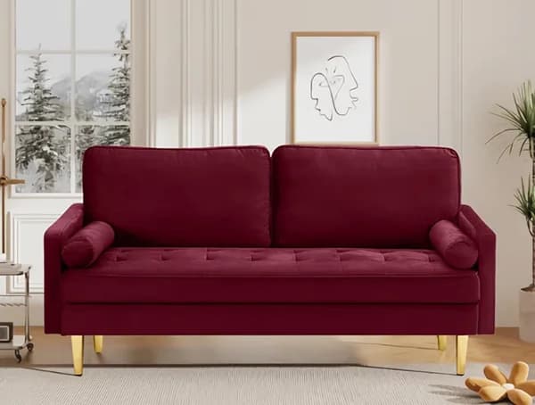 A deep red velvet sofa in the bright, plant-filled waiting area.
